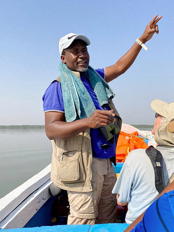 Modou Jarju en observation sur un bateau avec ses clients