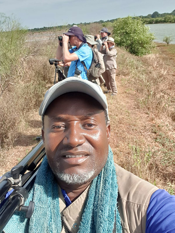 Modou Jarju en observation sur un sentier au Sénégal observant les oiseaux avec ses clients